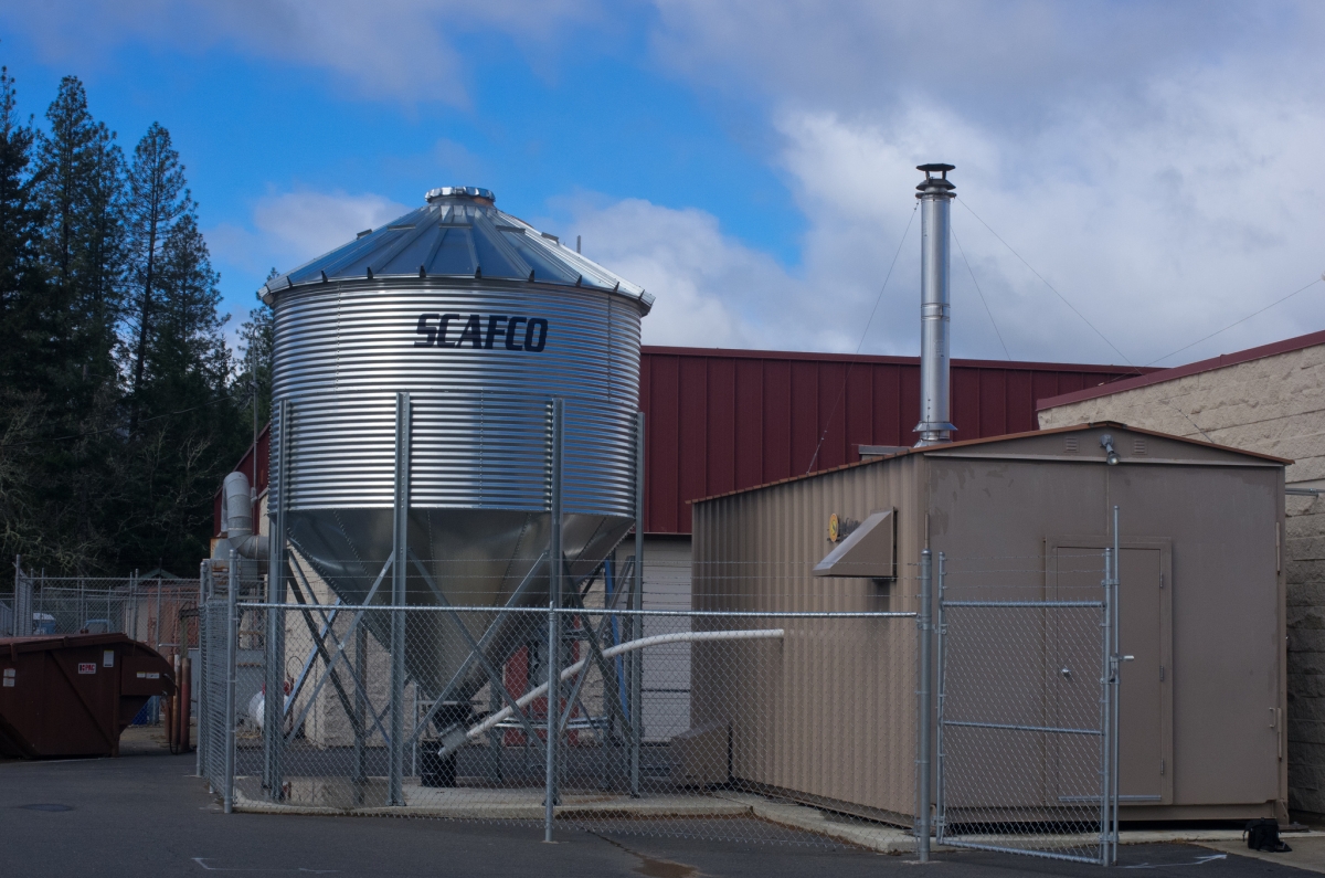 Figure 2: A biomass hopper (left) feeding into a biomass boiler room. Image courtesy of the Oregon Department of Forestry.